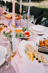 Elegant outdoor brunch display with colorful dishes and floral decor in a garden setting