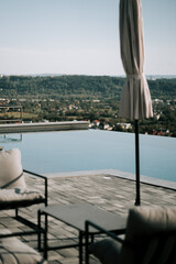 Modern infinity pool overlooking a lush green valley during a sunny afternoon