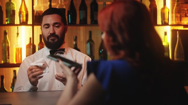 Curious barman wiping glass and listening to drunk woman calling ex-boyfriend