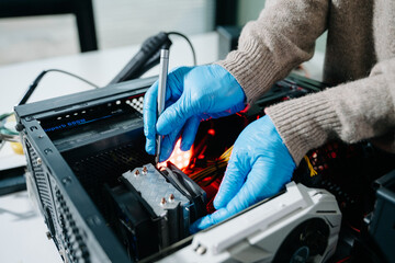 Computer technician in gloves safely repairing desktop hardware. Close-up view of hands fixing GPU...