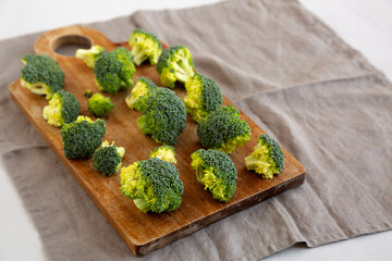 Raw Organic Green Broccoli on a Wooden Board, side view. Copy space.