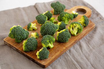 Raw Organic Green Broccoli on a Wooden Board, side view.