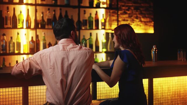 Attractive redhead female flirting with man at bar counter, looking for a date