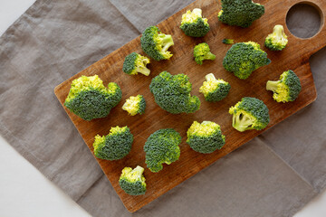 Raw Organic Green Broccoli on a Wooden Board, top view.