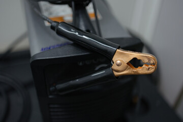 Detailed close-up of welding equipment showcasing copper welding clamps on an industrial welder