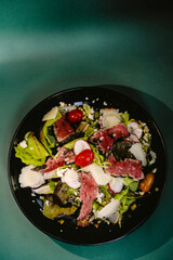 Tuna tataki salad fish food dish on a black plate. Japanese food