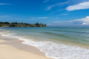 Tropical Beach with White Sand and Calm Waves under Blue Sky