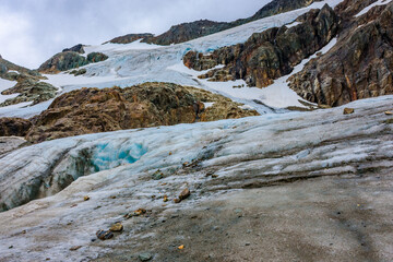 Vinciguerra Glacier’s massive ice wall with sharp crevices looming over tranquil lagoon waters