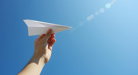 푸른 하늘을 향해 종이 비행기를 날리다. 어린 시절 순수한 꿈과 희망을 떠올리게 하는 종이 비행기.