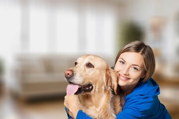 A young kind happy woman hugs cute dog.
