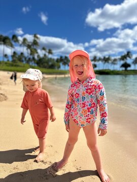 Fillettes rieuses sur la plage en chemisette fleurie
