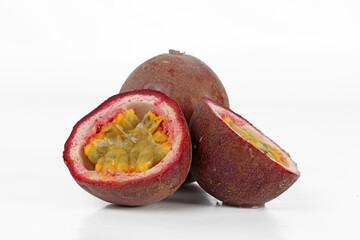 Whole and halved passion fruits (maracuja), close-up on a white background