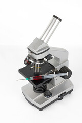 Microscope with a blood syringe on a white background
