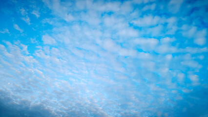 clear blue sky covered with small white clouds