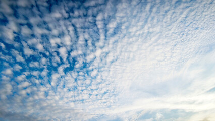 clear blue sky covered with small white clouds