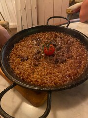 Meat and tomato risotto served in a small cast iron pan