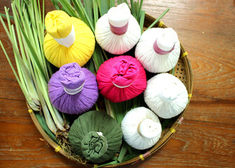Top View of Colorful Thai Herbal Compress Balls in Basket with Lemongrass for Thai Spa, Ayurvedic...