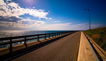 劇的な空と太陽光が反射する海沿いの道路