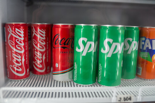 Chilled Coca Cola classic, Zero, Sprite, Fanta orange soda lined up inside pristine white refrigerator, waiting for refreshment