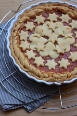 Close-up of homemade peach pie or tart on gray and white striped napkin on wooden table  
