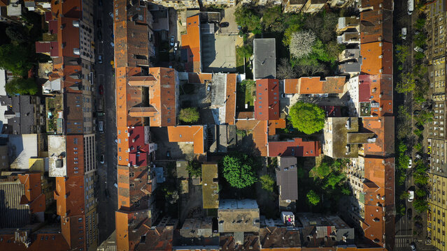 Aerial view of the city's rooftops, a dense patchwork of terracotta tiles contrasting with the verdant courtyards nestled within the urban fabric, Zagreb, Zagreb, Croatia.