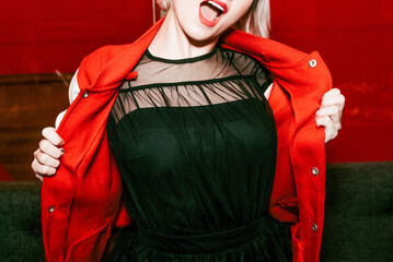 Young cheerful beautiful woman putting on red stylish outfit bomber jacket