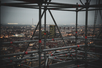 Aerial view of the city lights twinkling against the dark sky, seen through the scaffolding, Zagreb, Zagreb, Croatia.