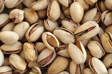 Many tasty unpeeled pistachios top view flat lay background pattern