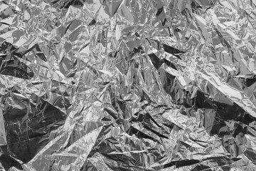Silver crumpled foil texture on flat surface