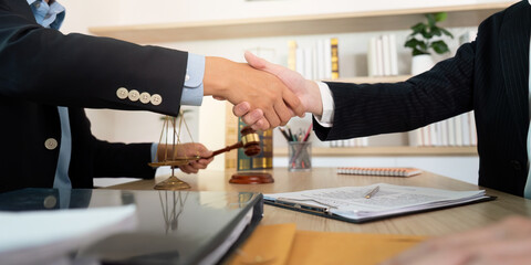 Legal Agreement. Lawyers shaking hands with a gavel and scales in view.