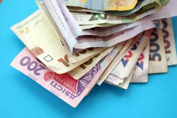 Ukrainian money bills on light blue paper background