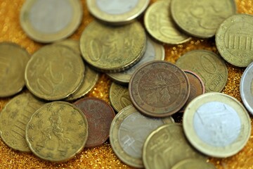 Big amount of euro coins on golden glitter background