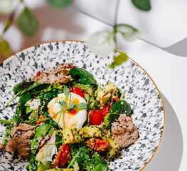 Fresh salad bowl with poached egg and assorted ingredients at a brunch setting