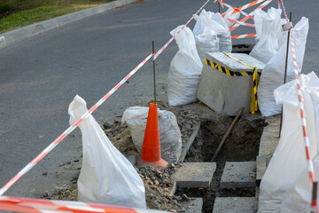 Road construction blocks access with safety barriers and equipment as workers focus on repairing...