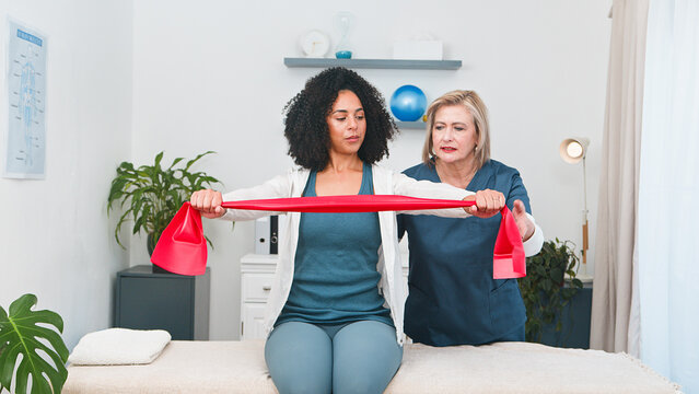Senior Physiotherapist Guides Young Black Client Through Resistance Band Exercises Rehabilitation and Strength Training