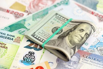Nigerian naira currency money bills and bunch of us dollar banknotes. The concept of economics and currency exchange