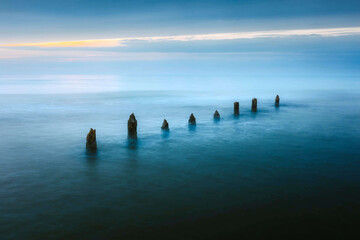 Serene Seascape with Weathered Pilings at Blue Horizon