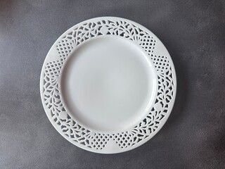 Empty white dish plate on dark background. Top view