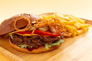 Burger with pulled beef, onion rings and fries.