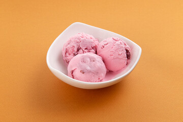 Three scoops of ice cream in a bowl.