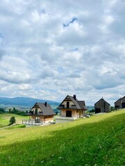 Obraz premium Traditional modern houses near Czorsztynskie lake with Tatra mountain background. Concept: rural lifestyle, eco living, authentic travel. 