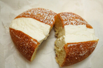 Maritozzo, an Italian sweet bread filled with whipped cream cut in half, viewed from directly above