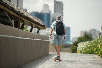 Senior man riding an electric skateboard in the city