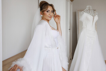 Bridal preparation in a bright room with wedding dress and elegant attire