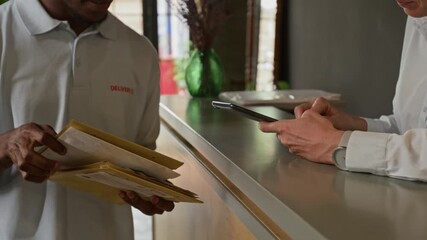 Close up of unrecognizable black courier giving tablet to unrecognizable woman nd starting choosing registered letter