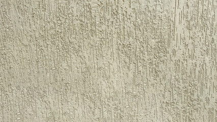 Beige plaster wall texture with vertical rough patterns, natural rustic background for design, construction, interior, and architectural use.