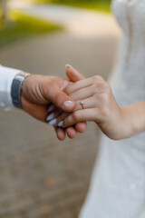 Couple holding hands during outdoor wedding ceremony in a garden setting