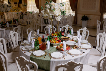 Elegant dining setup at a banquet hall featuring a large round table with gourmet food and drinks