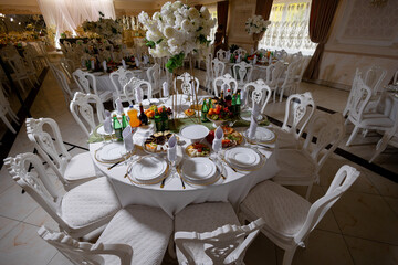 Elegant dining setup for a special event in a decorated venue with floral arrangements