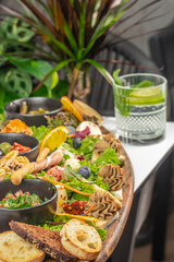 Assorted antipasto platter with meats, cheeses, vegetables, and bread served with cocktail